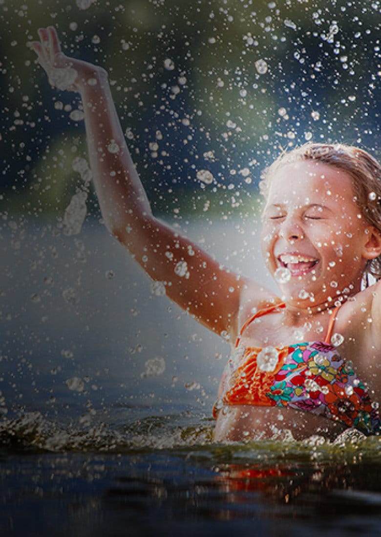 lcaf_child-playing-in-a-lake_mobile lfac joyful young girl splashing in lake water during summer camp activity